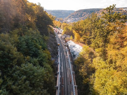 Autumn landscape with construction on railroad tracks and surrounding forest in the sun, Bau der