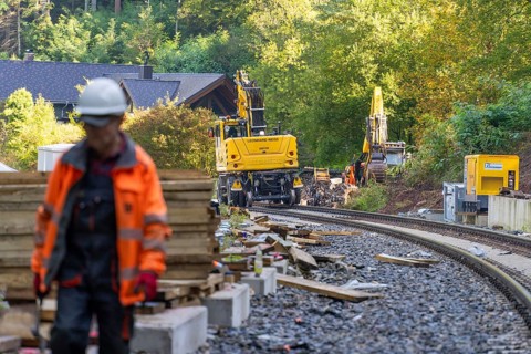 A worker on a construction site with construction machinery in the background, Bau der Hermann,