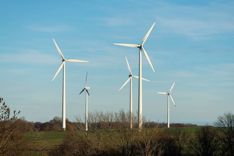 Wind turbines stand on a wide meadow under a clear blue sky, Swabian Jura, Baden-Württemberg,