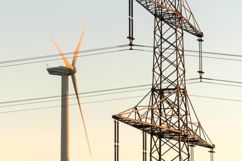 Wind turbine next to a power pole with wires, technical motif, Swabian Jura, Baden-Württemberg,