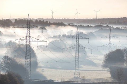 Foggy landscape with power poles and wind turbines at dawn, Swabian Jura, Baden-Württemberg,
