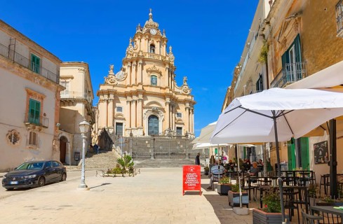 Tourists sitting in local restaurants in the main square, Ragusa Ibla, Ragusa province, Sicily,