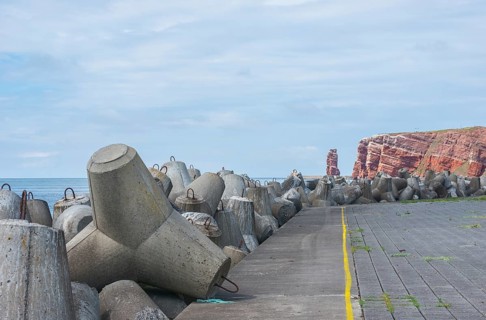 Coastline with concrete tetrapods at sea, coastal protection, protective wall, paved coastal strip