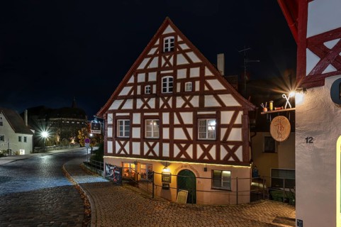 Night view of the historic half-timbered house, on the right the nose sign of a tailor shop, Lauf