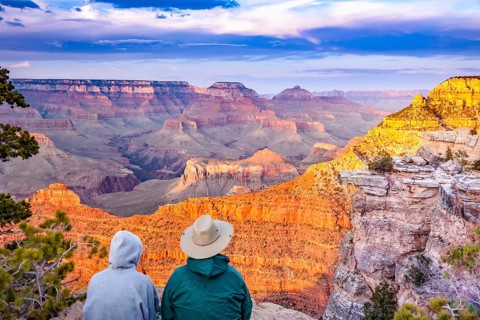 Couple enjoying the beautiful landscape of the grand canyon sunset