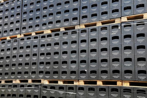 Stacked black beer crates from the Kulmbacher Group, a beverage manufacturer that includes