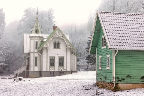 Idyllic old wooden house with beautiful carpentry and a garden shed a frosty and snowy cold misty