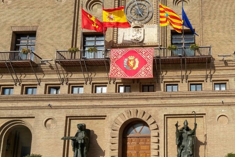 Flags flying Ayuntamiento city hall building, Plaza del Pilar, city centre of Zaragoza, Aragon,
