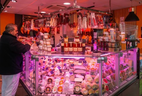 Market stall shop store selling cheese and delicatessen meat products inside Mercado Central de