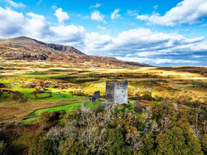 Autumn colours over Castell Dolwyddelan and Eryri Mountains from a drone, Snowdonia, Conwy County