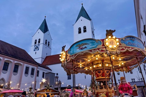 Illuminated old children's carousel, historic nostalgia carousel year 1888, Christmas market,