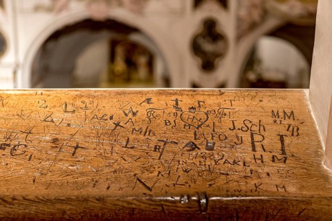 Initials, inscriptions, signs, doodles, graffiti, carved by bored churchgoers in church stalls,