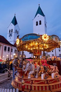 Illuminated old children's carousel, historic nostalgia carousel year 1888, Christmas market,