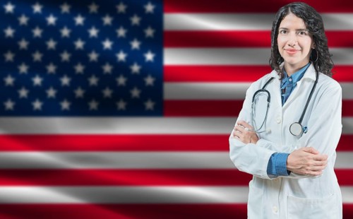 American medicine and healthcare concept. Doctor close up against United States flag background