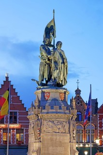 Illuminated monument to Jan Breydel and Pieter de Coninck in the evening light on the market square