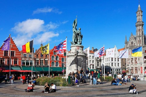 Monumental monument to Jan Breydel and Pieter de Coninck in front of historic houses on the lively