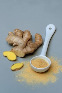 Ginger root and ginger powder in spoon, Zingiber officinale