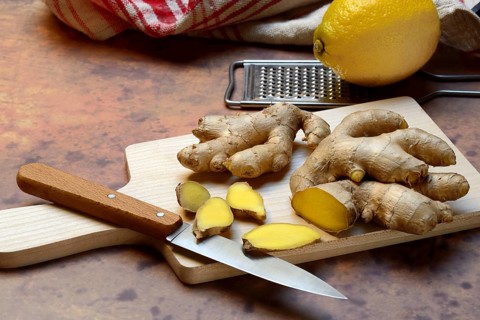Ginger, ginger root cut with ginger slices on wooden boards