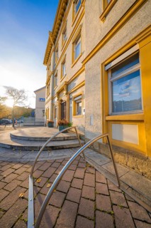 Historic building with entrance area, warm sunlight on paved courtyard, Aidlingen, Böblingen