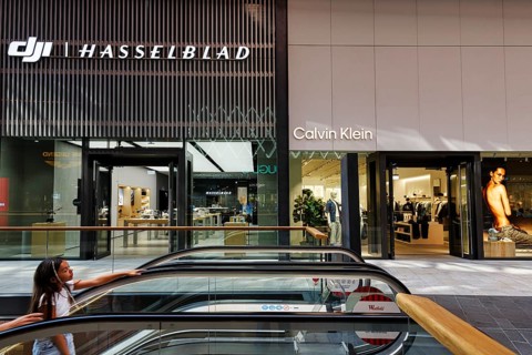 Shop window with logo, Hasselblad and Calvin Klein lettering, escalator, Westfield Überseequartier,