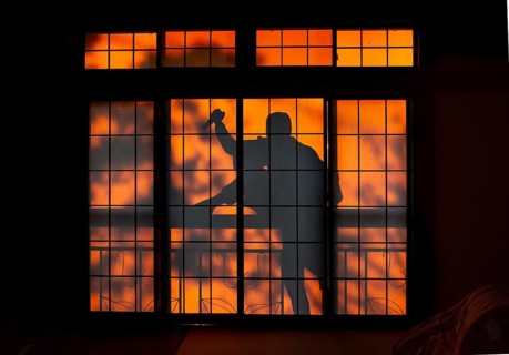 Shadow of a man climbing over balcony railings, burglar with knife, assassin, ninja, on the balcony