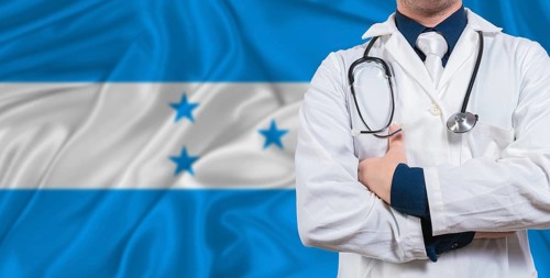 Male doctor with stethoscope on Honduras flag. Doctor holding stethoscope on Honduras flag