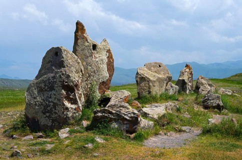 Protruding stones in a meadow under a cloudy sky, stone circle, megaliths, Zorats Karer,