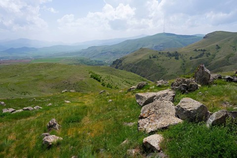 View of a hilly landscape with scattered stones and a wide panorama, landscape near Zorats Karer,