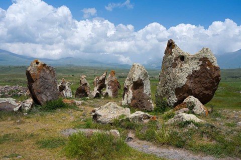 Stone monuments on a vast meadow under a cloudy sky, stone circle, megaliths, Zorats Karer,