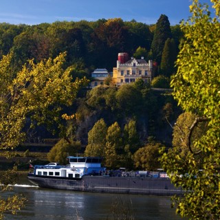 Marienfels Castle with cargo ship on the Rhine River, former residence of entertainer Thomas