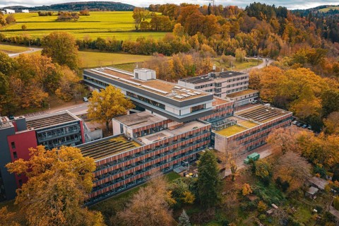 Building complex surrounded by autumnal nature with advanced roof design, Calw District Office,