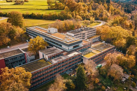 Building complex in a hilly, autumnal area with flat roof and solar cells, Calw District Office,