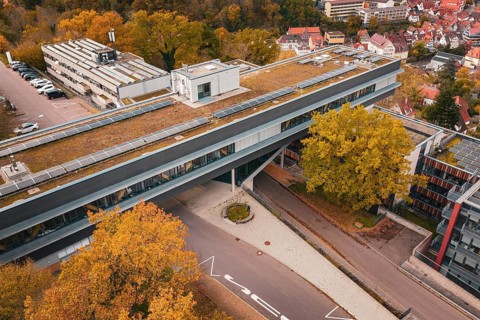 Roof view of a modern building with solar panels and surrounding autumn trees, Calw District