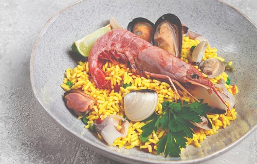 Seafood paella, on a plate, traditional Spanish dish, top view, no people