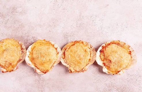 Scallop, baked in shells, with cheese and spices, on the table, homemade
