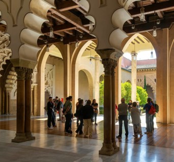 Tour group tourists viewing Moorish arches, Aljafería Palace, Zaragoza, Aragon, Spain