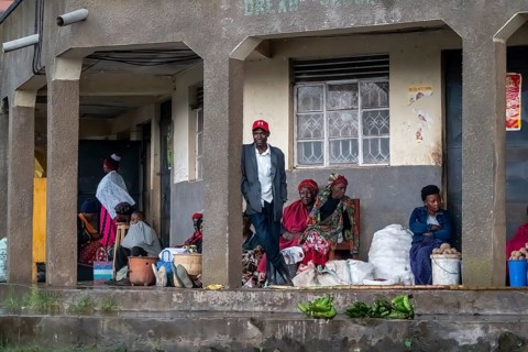 Street scene, people waiting outside houses for the rain to end selling vegetables, Kisoro, Uganda
