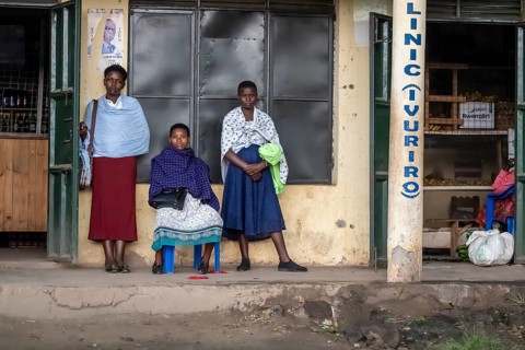 Street scene, people waiting outside houses for the rain to end, Kisoro, Uganda