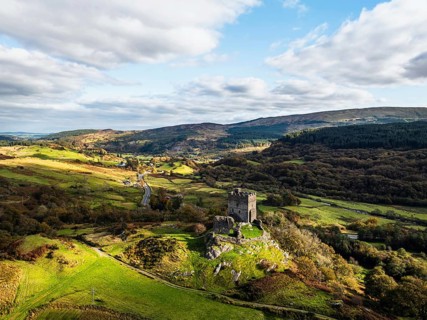 Autumn colours over Castell Dolwyddelan and Eryri Mountains from a drone, Snowdonia, Conwy County