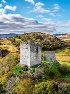Autumn colours over Castell Dolwyddelan and Eryri Mountains from a drone, Snowdonia, Conwy County