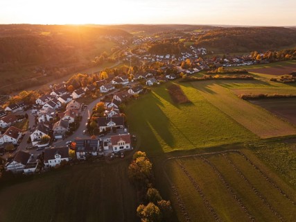 Wide view of a village on a sunny autumn evening with fields and hills, Deufringen, Aidlingen,
