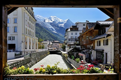 Glacier river Arve flows through the city, with the snow-capped Mont-Blanc mountain range behind,