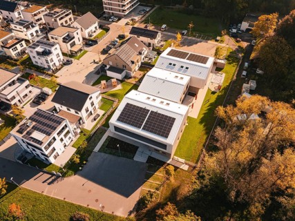 Aerial view of a modern residential area Kita Hasenbrunnen with solar panels and autumn