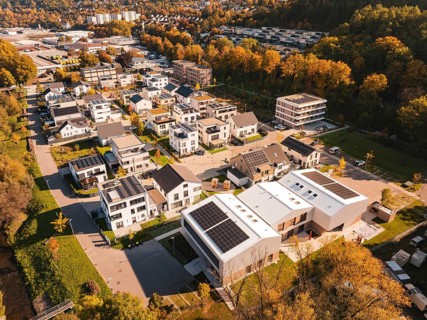 A residential area with modern houses and solar panels, surrounded by autumn trees, Nagold, Black
