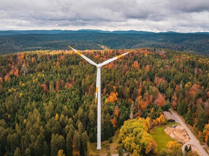 Wind turbines in autumn forest surrounded by clouds and roads, Simmersfeld wind farm, Germany