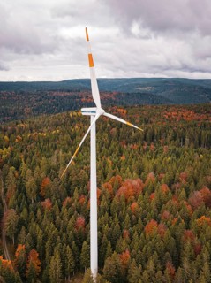 Wind turbine over autumn tree landscape under cloudy sky, Simmersfeld wind farm, Germany