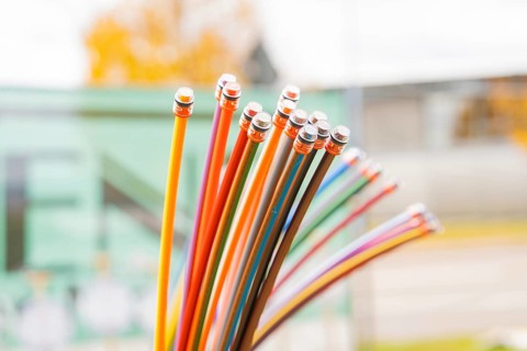Bundle of colorful fiber optic cable in a green blurred background, optical fiber