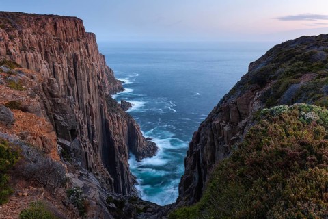 The Gap with long exposure shows the sunset over the cliffs of Cape Raoul. Golden light hits the
