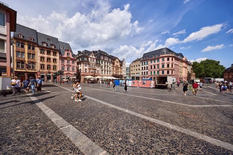 Square made of paving stones and marble slabs with pattern, row of houses, reconstructed historic