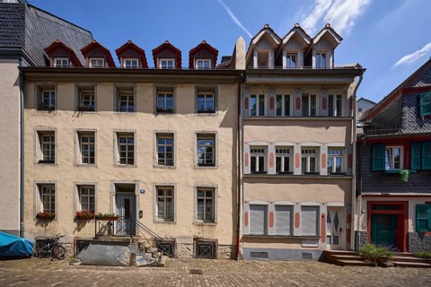 Historic buildings, houses, downpipes, façade with windows, dormers, stairs and doors, paving stone
